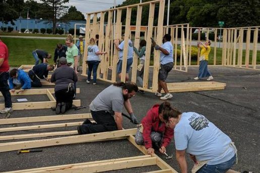 A photograph of Acts of Service volunteers building homes for Habitat for Humanity.