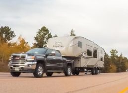 Photo of pickup towing fifth-wheel trailer down a highway