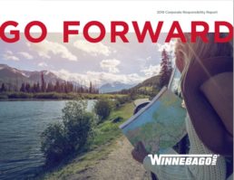 The front cover of Winnebago's corporate responsibility report, which shows a photo of two women looking at a map as they stand beside a wide river with mountains in the background. The words "Go Forward" are superimposed on the top of the image.