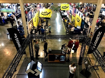 A picture from above of a giant expo hall with people lingering at different booths