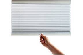 A picture of a hand adjusting a cordless pleated window shade