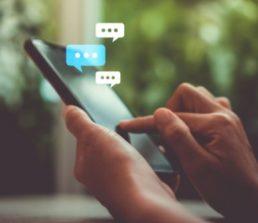 Hands using smartphone to send text message