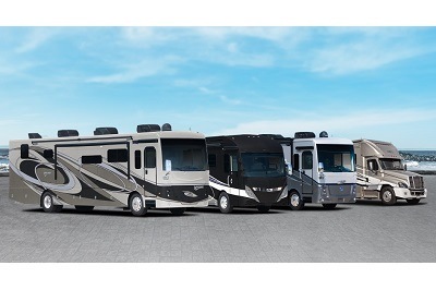 A photograph of four REV Group RVs in front of a blue sky