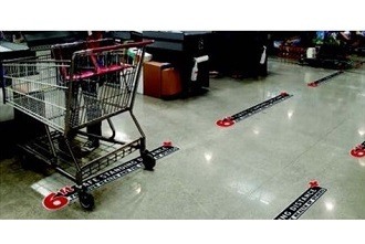 A picture of a shopping cart next to graphics on a tile floor indicating six-foot intervals