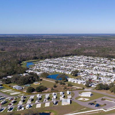 An aerial photo of Cross Creek RV Resort showing rows and rows full of parked RVs. The campus also shows some water features and space for park models.