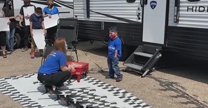 A picture of Marcos tapia receiving a Make a Wish travel trailer