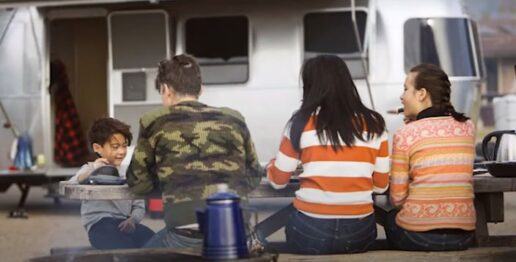campers eating lunch outside a travel trailer
