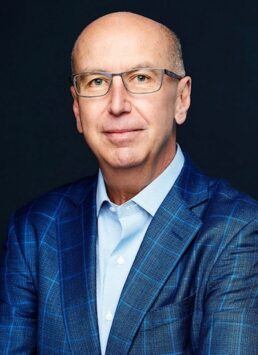 A head and shoulders picture of OmniMax International CEO John C. Wayne