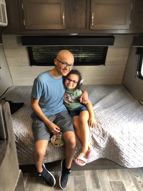A picture of Make-A-Wish recipient Misael and his sister inside their new camper