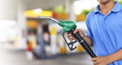 A picture of a man preparing to pump gas at a gas station