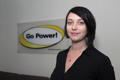 A picture of Go Power Marketing Manager Eva Mitic standing in front of a white wall with a Go Power logo on it