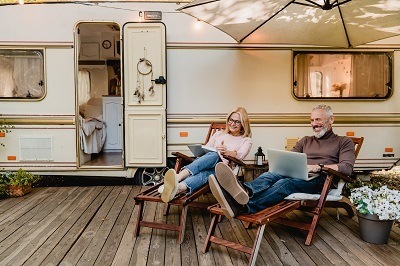 A picture of an RV couple relaxing outside on vacation