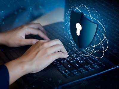 A stock cyber attack image of hands typing on a computer keyboard with a lock symbol floating above the computer