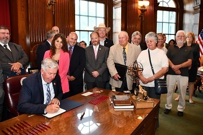 A picture of Missouri and ARVC representatives around the Missouri governor signing a bill into law.