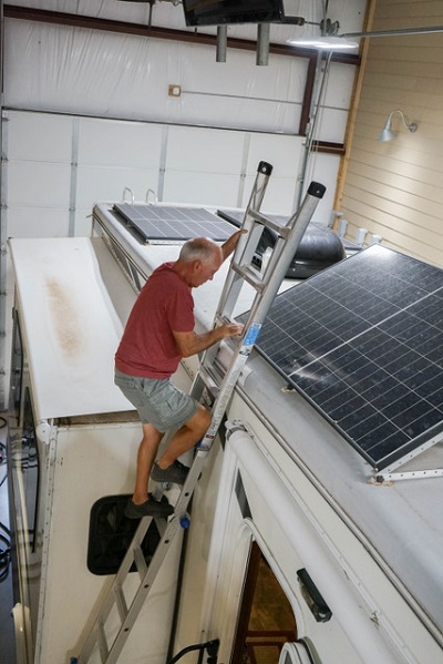 A picture of NRVTA student Blaine Lewis preparing to perform a solar sytem installation on the roof of an RV.
