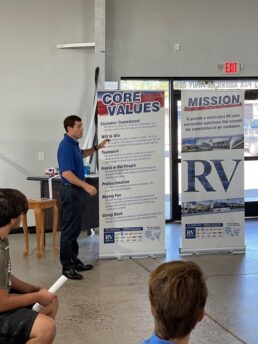 A picture of RV Retailer President and CEO Jon Ferrando discussing the company's values to new Aloha RV employees