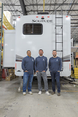 A picture of Cam Boyer, Grand Design RV chief financial officer; Rob Groover, Solitude and Momentum general manager; Tommy Hall, Solitude product manager, standing in front of a Solitude RV.
