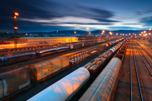 A freight station rail yard with trains on the tracks.