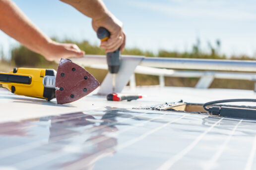 A stock photo of a man fixing an RV roof.