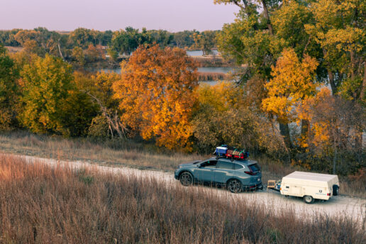 A picture of an SUV pulling a pop-up travel trailer.