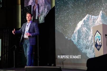 A picture of Lippert CEO Jason Lippert on stage delivering a keynote address during the Purpose Summit at Notre Dame University