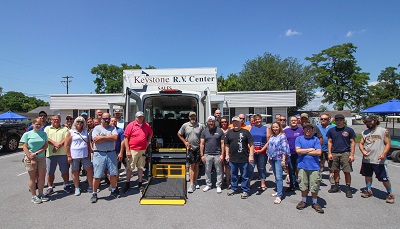 A picture of staff of Keystone RV Center gathered outside a trailer for a community event