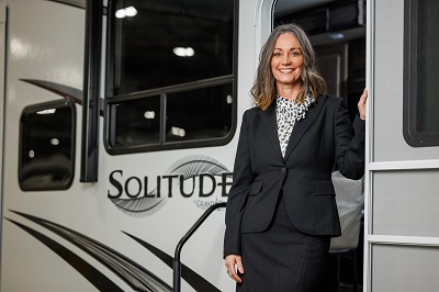 A picture of Mary Minix, Grand Design RV vice president of human resources, standing on the steps outside a Solitude RV