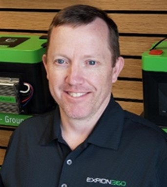 A picture of Expion360 CAO Greg Aydelott in front of two Expion360 products