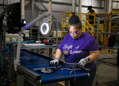 A picture of Operator Kim Flemming building a GE water heater burner assembly in Camden, South Carolina