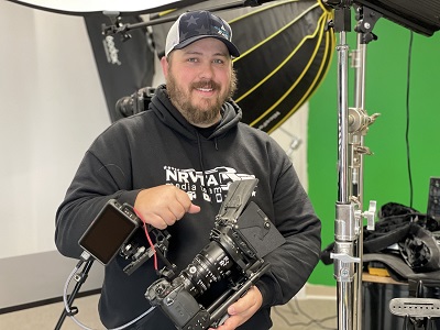 A picture of Garrett Syfrett, NRVTA Video Production Manager, holding a video camera.