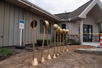 A picture of seven shovels stuck vertically in the dirt at Jayco health clinic groundbreaking event.