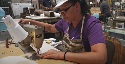 A picture of a woman at a sewing machine at Lance Camper Manufacturing