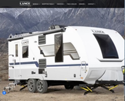A picture of a travel trailer with a mountain backdrop.