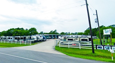 A picture of LLoyds RV Center in Texas showing a driveway leading to multiple pull-behind Rvs.