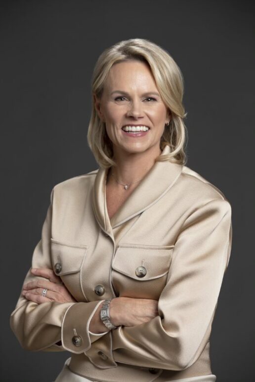 A picture of a woman named Molly Fletcher in a silk shirt, her arms are crossed.