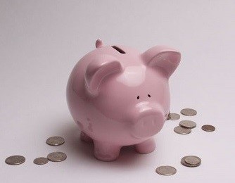 A picture of a piggy bank with coins around it