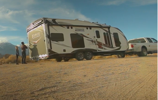 A picture of a couple at the rear of their towable RV