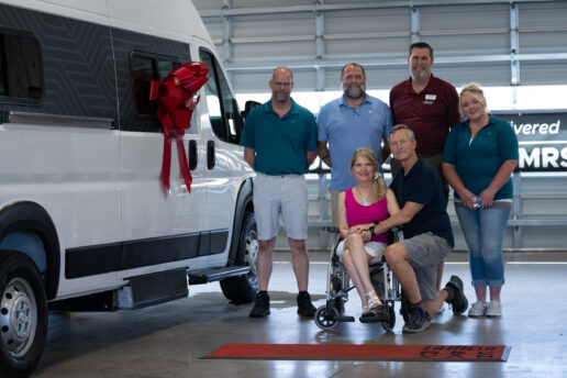 A picture of the June 2022 delivery of the Winnebago Roam with six people including the van owner in a wheelchair