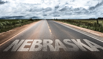 A picture of the word Nebraska overlaid over a picture of the open road vanishing into the prarie