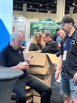 A picture of Bill Walton signing basketballs at the Carefree of Colorado booth.