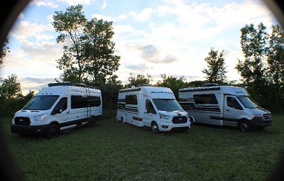 A picture of three Chinook RV Type B motorhomes on a grassy field.