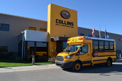 A picture of a school bus parked outside of a Collins Bus building.