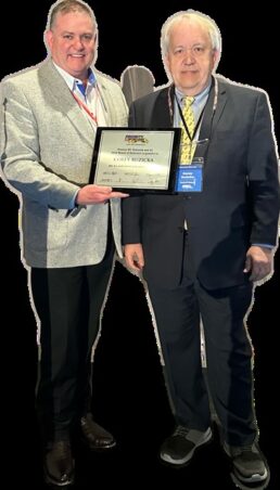 A picture of Priority RV Network President Mike Regan presenting an award to Corey Ruzicka.