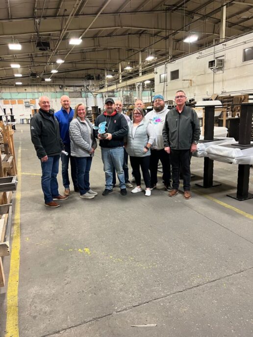 A picture of the Custom Wood Products staff showcasing their Jayco Blue Excellence Award.