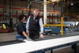 A picture of Dometic's Jessica Vasquez (L) and Dometic Segment Land Vehicle Americas President Todd Seyfert examining awning material at Dometic's awning manufacturing plant in Elkhart, Indiana.