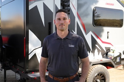 A picture of Lance Camper marketing manager Jim Waters standing outside an Enduro off-road travel trailer.
