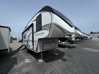 A picture of numerous Keystone RV Cougar fifth wheels lined up on an RV dealer lot
