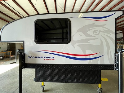 A picture of the 2023 Soaring Eagle Truck Camper in a shop floor on wheels