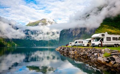 A picture of motorhomes by a lake and the misty mountains
