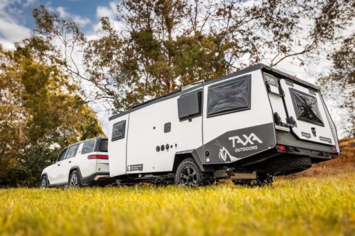 A picture of an SUV towing a Taxa Outdoors RV.